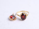 two rings with garnets on them on a white surface