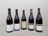 four bottles of wine are lined up on a table