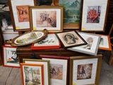 de nombreux tableaux encadrés posés sur une table sur laquelle se trouvent des photos