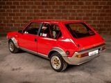 a red car that is parked in front of a brick wall