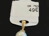 a close up of a white tag with a pearl on it