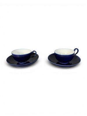 deux tasses et soucoupes, les soucoupes posées sur un fond blanc