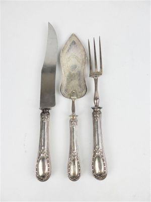 trois fourchettes et un couteau sur une table blanche