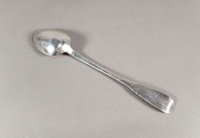 une cuillère en argent avec un manche de cuillère sur une table