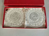 deux dessous de verre en verre dans une boîte rouge posée sur une table