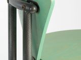 a close up of a green chair with a metal frame