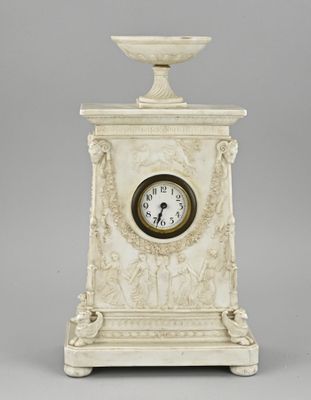 a white marble clock with a bowl on top of it