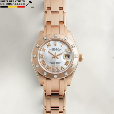 a close up of a watch on a white surface with a white background