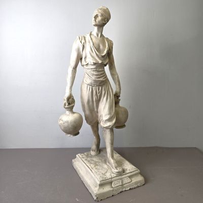 statue d'une femme tenant une cruche d'eau, posée sur un socle