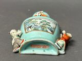 a small blue vase with animals on it sitting on a table