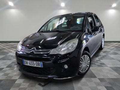 la petite voiture noire est garée sur un carrelage à carreaux