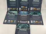 a set of six star wars books on a white surface