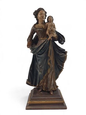 statue of a woman holding a child on a wooden base
