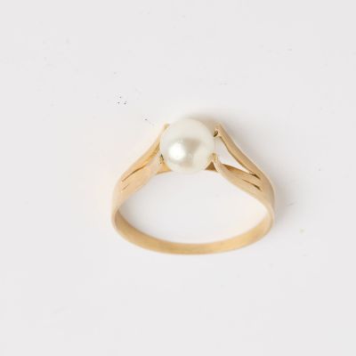 une bague en or avec une perle au centre
