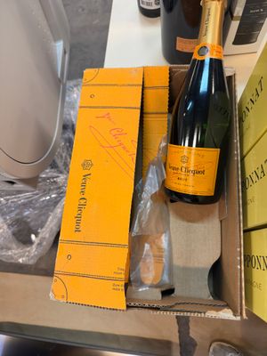 une bouteille de champagne posée sur une table à côté d'une boîte de livres