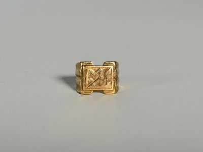 gros plan d'une bague en or sur une surface blanche