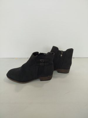 une paire de bottines noires posées sur une surface blanche