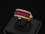 a ruby and diamond ring on a black surface