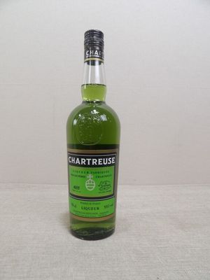 une bouteille d'alcool vert posée sur une table