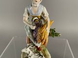 a figurine of a woman holding a basket of flowers