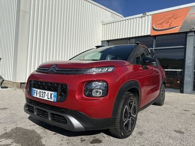 une citrole rouge garée devant un immeuble