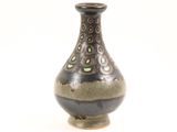 a brown vase with green dots on it on a white background