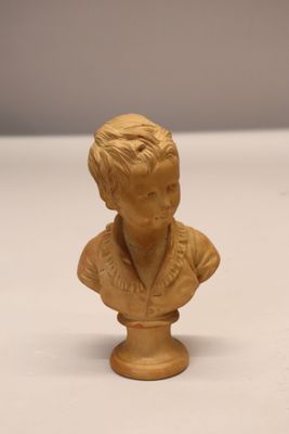 an image of a small statue of a boy on a white surface