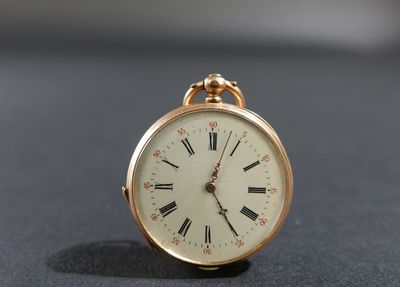 une montre de poche en or avec des chiffres romains sur le cadran