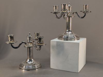 un candélabre en argent et un candélabre en argent posés sur une table