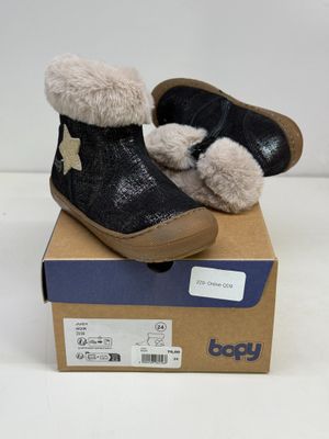 une paire de chaussures pour bébé dans une boîte posée sur une surface blanche