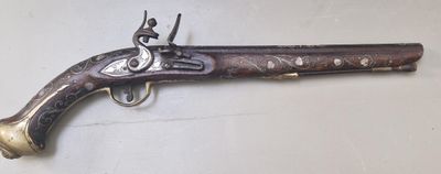 un vieux pistolet accroché au mur