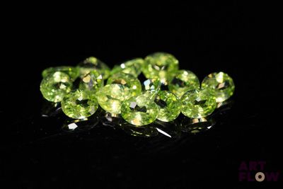 a close up of a bunch of green diamonds on a black surface