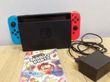 the nintendo switch is next to a nintendo game console and a charger