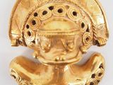 a close up of a gold object on a white surface