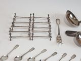 a lot of silverware on a table with forks and spoons