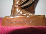 a bronze statue of a woman holding a book