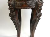 une vieille table en bois avec un plateau et des pieds sculptés