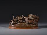 une statue en bronze représentant un homme à cheval, avec un panier posé sur la selle