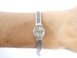 wrist of a woman with a silver watch on it ' s wrist