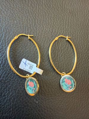 une paire de boucles d'oreilles créoles en or ornées de fleurs