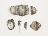 une photo d'une broche en argent, d'une épingle et d'autres objets