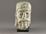 a white marble head of a man with a beard and a hat