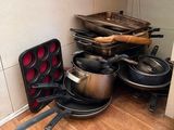 de nombreuses casseroles et poêles qui traînent par terre dans la cuisine