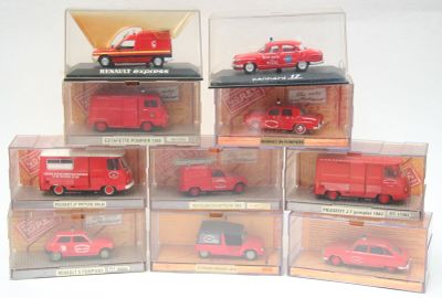 Six petites voitures rouges sont exposées dans une vitrine posée sur une surface blanche.