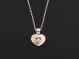 un pendentif en argent en forme de cœur, orné d'un diamant, monté sur une chaîne