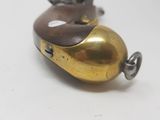 a small brass object on a white surface