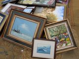 a lot of framed pictures on the floor of a room