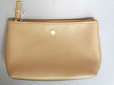 porte-monnaie en cuir beige avec fermeture éclair dorée et chaîne sur fond blanc
