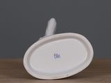 a white plate with a blue flower on it on a wooden table