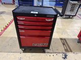 craftsman ' s tool box on wheels in a garage with tools in the background